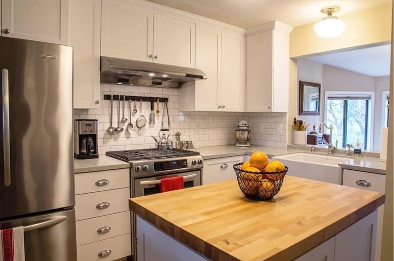 modern farmhouse kitchen with subway tile and butcher block island Leslie Kate Photo